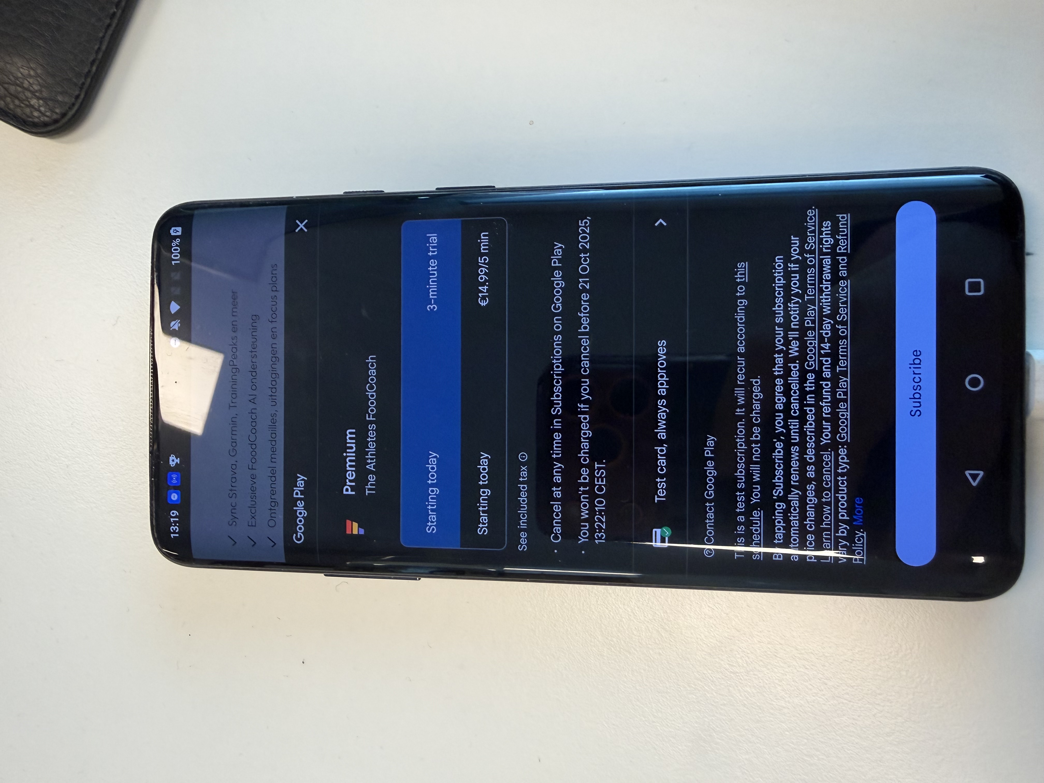 Android phone showing a subscription popover with the payment method "Test card, always approves"